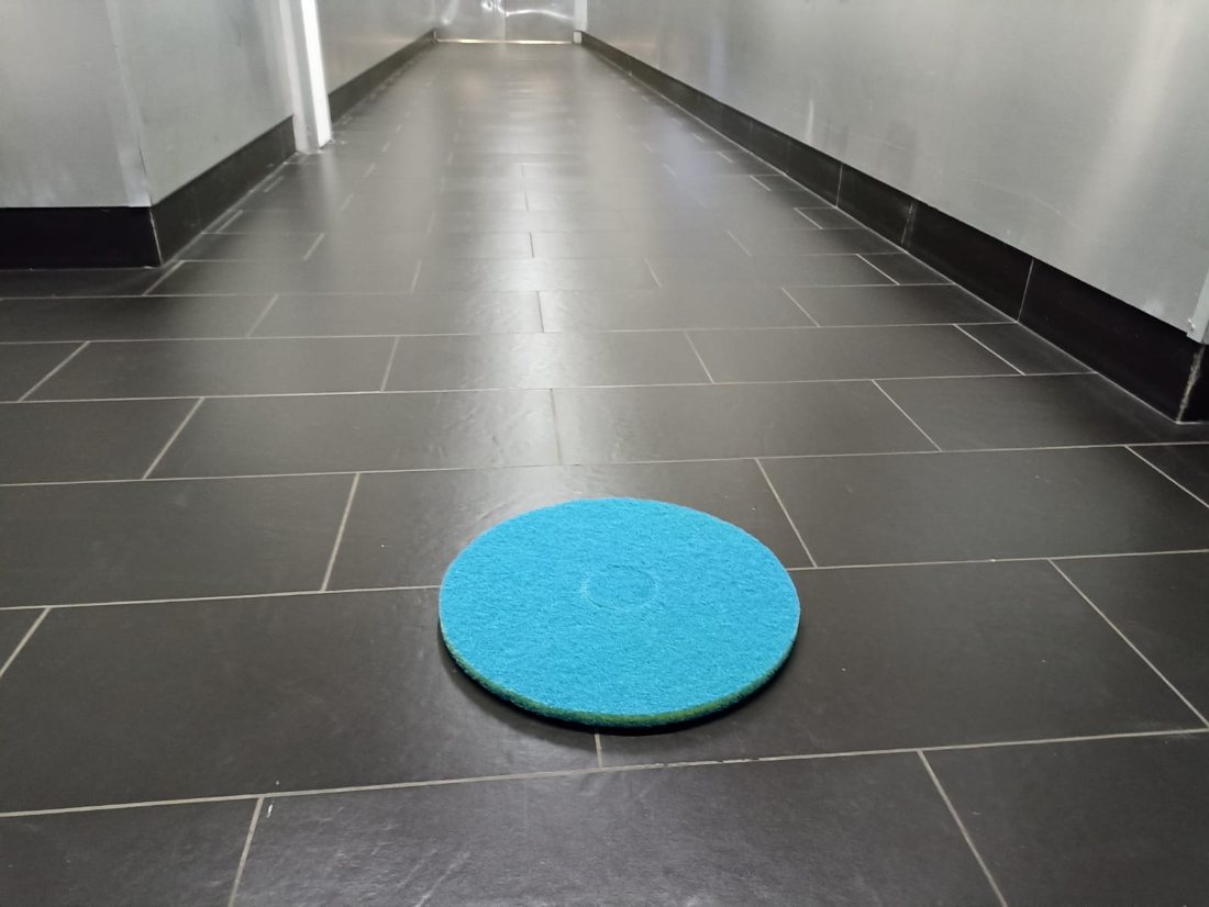 Disque Biface posé sur un carrelage sombre dans un couloir